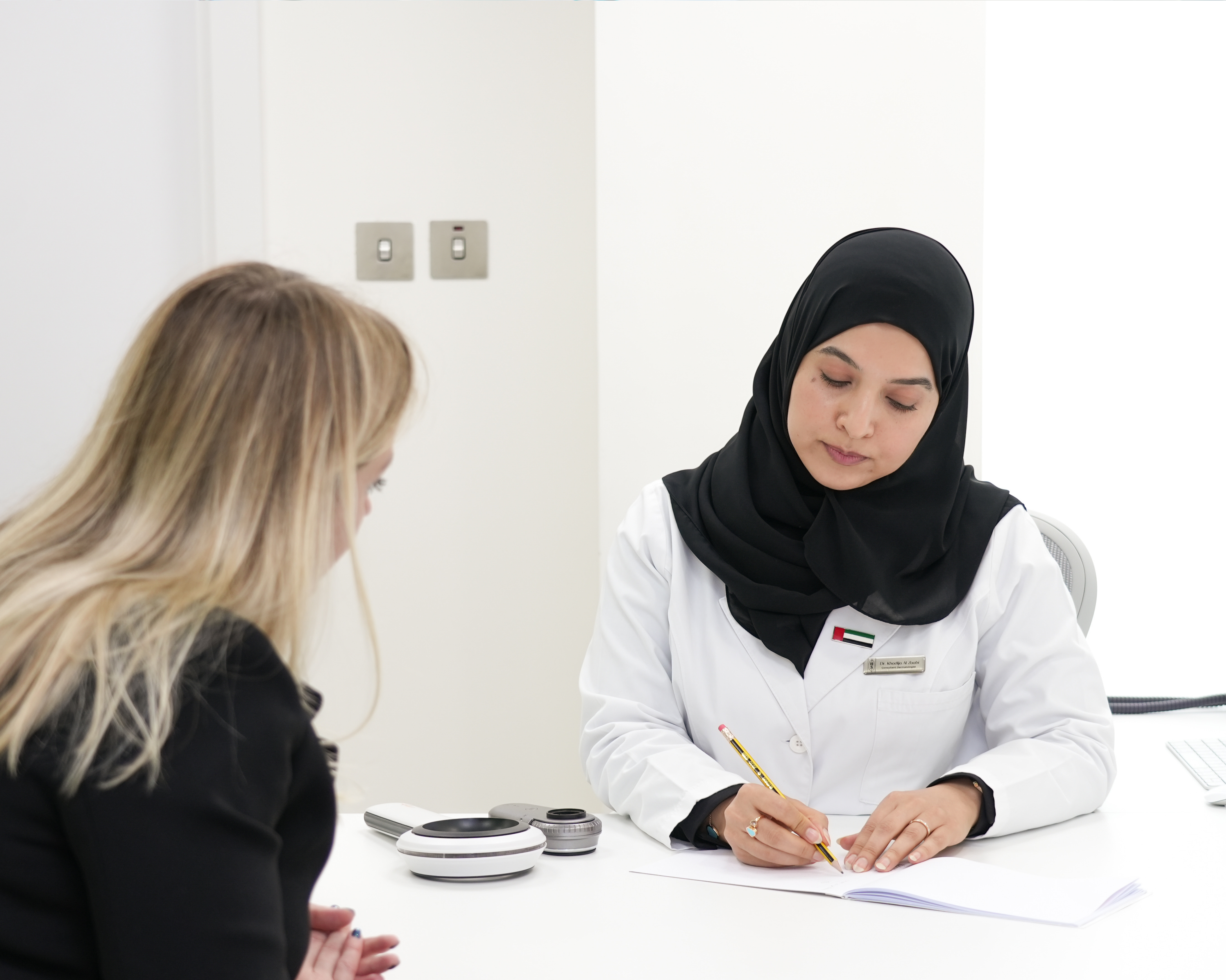 Dr. Khadija conducting a dermatology skin consultation in Abu Dhabi